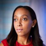 Haben Girma, a Black woman in her 30s, wears pearl earrings and a textured red dress. She looks thoughtful. The background has shades of purple and blue.