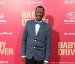 Actor CJ Jones standing in front of a pink poster for the movie Baby Driver. Photo by MojahediPhotography