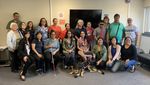 Twenty members of the Hawaii Deafblind community, from high school students to grandparents, stand together. Haben is wearing two leis gifted to her by the kupuna, the elders. One has smooth kukui nuts, the other has orchids, carnations, and tuberoses that smell AMAZING! Mylo, Haben's Seeing Eye dog, is stretched out on the floor in front of Haben