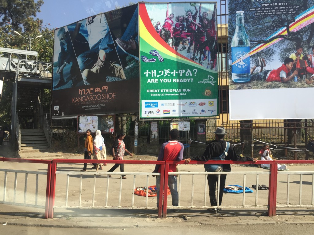 People walking under huge advertisements in downtown Addis.