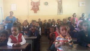 Young children sitting at their desks at the Victory School for the Deaf.