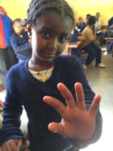 A young girl waves to the camera at the Victory School for the Deaf.