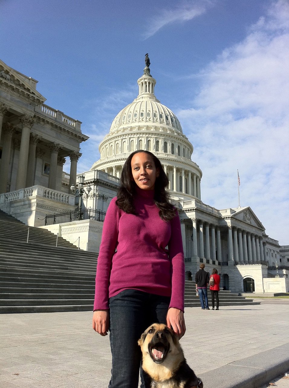 Haben Girma stands with her guide dog in front of the U.S. Capitol Building.