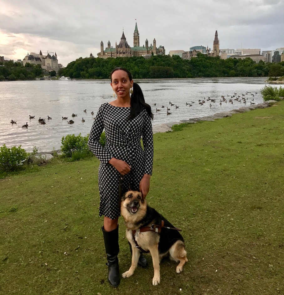 Haben standing next to the Ottawa River with Parliament Hill in the background