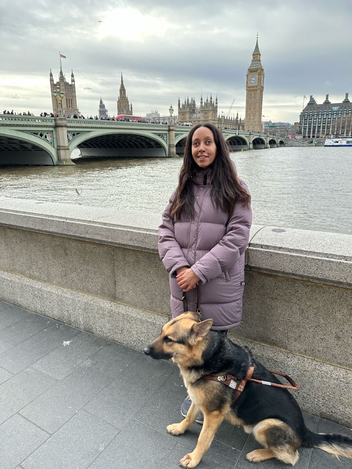 Mylo & I standing before the River Thames across from Parliament and Big Ben. Mylo, a German Shepherd, wears a brown leather and metal harness from The Seeing Eye in New Jersey.