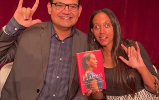 I’m sitting on stage with disability advocate and Deaf educator Yahir Alejandro. We’re signing ILY and holding up my book between us.
