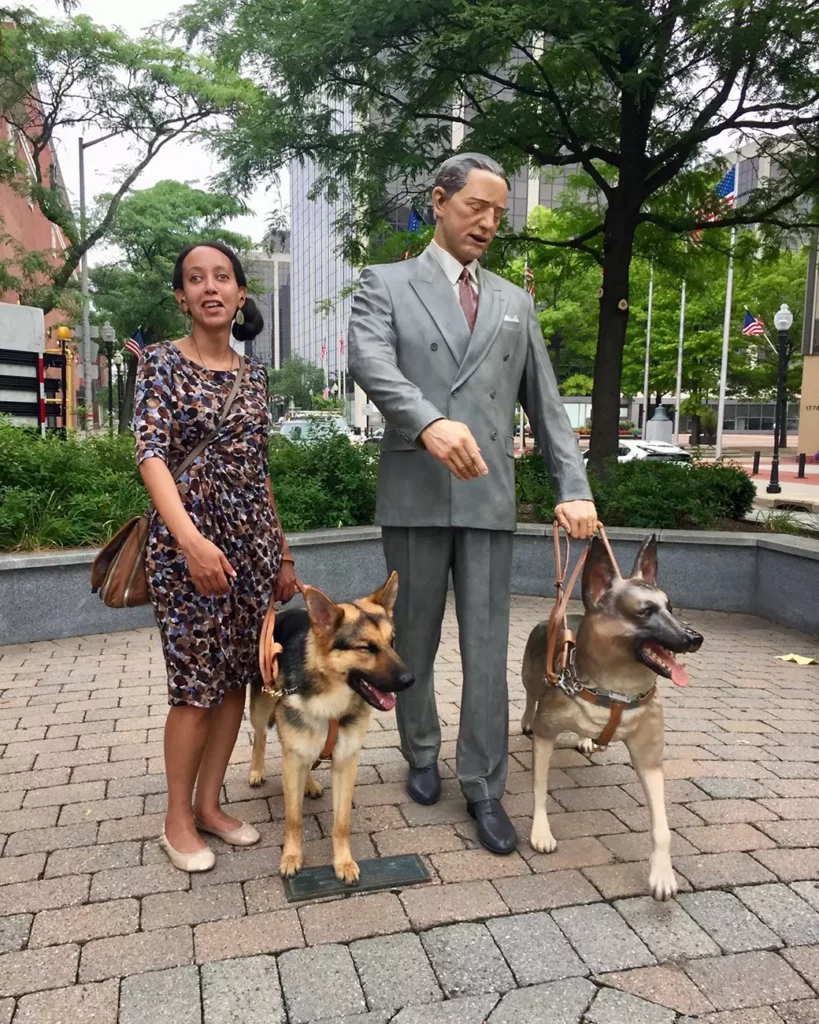 My guide dog Mylo & I are standing next to a statue of Frank Morris and his German Shepherd guide dog Buddy. The statue is in Morristown, NJ, and I was there in July 2018 to train with Mylo at The Seeing Eye.